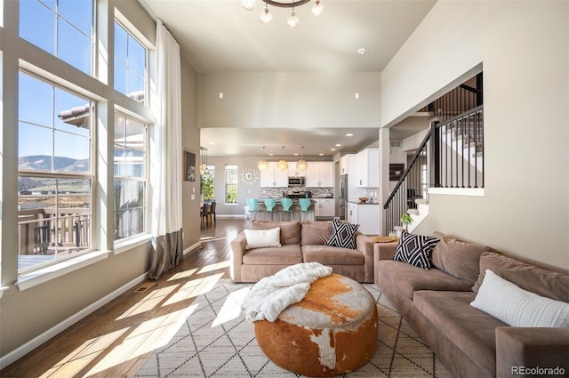 15194 W Washburn Ave, Lakewood, CO 80228 - living area with wood finished floors, a high ceiling, stairway, a chandelier, and a mountain view