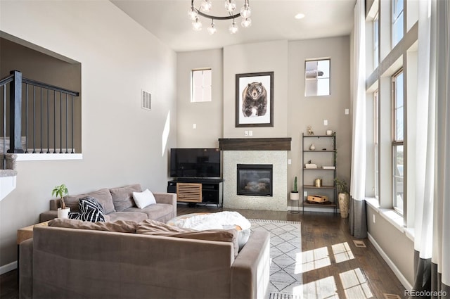 15194 W Washburn Ave, Lakewood, CO 80228 - living area with dark wood-type flooring, a glass covered fireplace, a chandelier, and a high ceiling