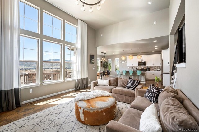 15194 W Washburn Ave, Lakewood, CO 80228 - living room with a chandelier, a high ceiling, and wood finished floors