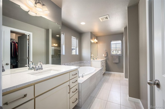 15194 W Washburn Ave, Lakewood, CO 80228 - full bathroom with a bath, two vanities, healthy amount of natural light, and a shower stall