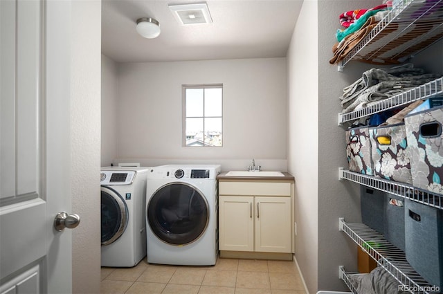 15194 W Washburn Ave, Lakewood, CO 80228 - washroom featuring independent washer and dryer, light tile patterned flooring, and cabinet space