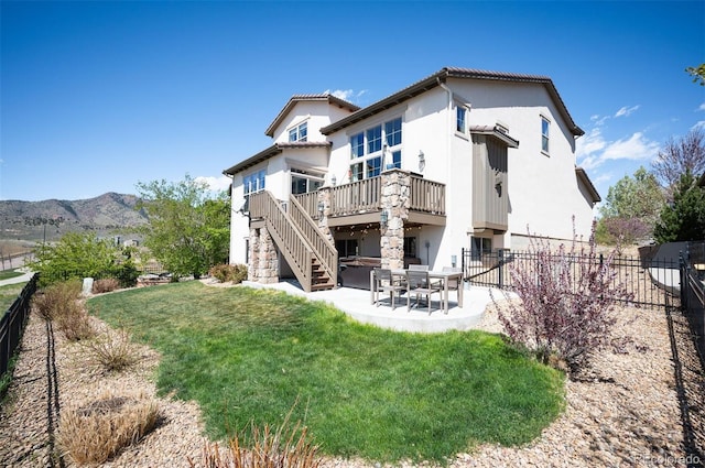 15194 W Washburn Ave, Lakewood, CO 80228 - rear view of house featuring a patio area, stucco siding, a deck with mountain view, and stairs