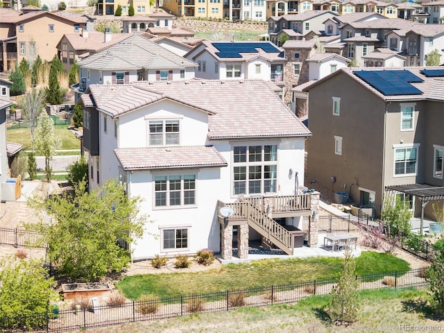 15194 W Washburn Ave, Lakewood, CO 80228 - rear view of house featuring stucco siding, a residential view, a tiled roof, and a fenced backyard