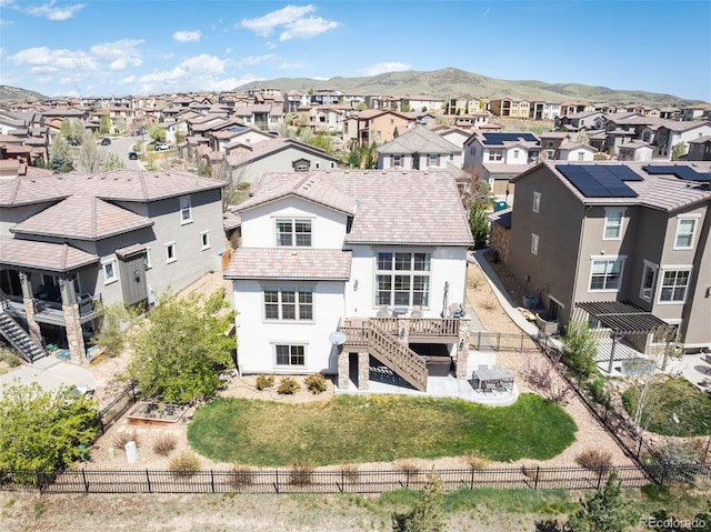 15194 W Washburn Ave, Lakewood, CO 80228 - back of house featuring a residential view, a fenced backyard, stucco siding, a tiled roof, and stairs