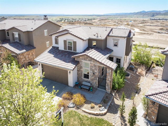 15194 W Washburn Ave, Lakewood, CO 80228 - view of front of home with stone siding, stucco siding, a tile roof, and an attached garage