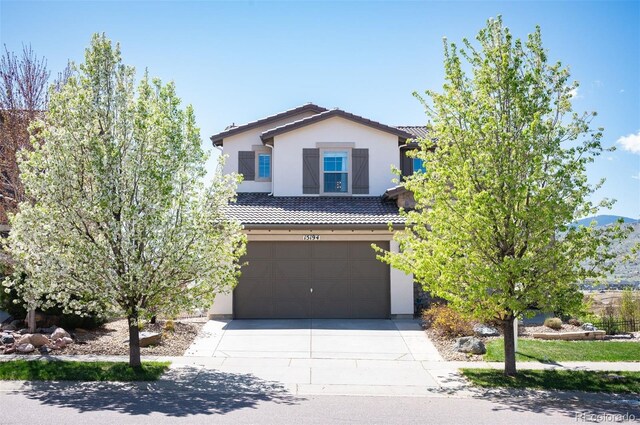 15194 W Washburn Ave, Lakewood, CO 80228 - traditional home with stucco siding, concrete driveway, a garage, and a tiled roof