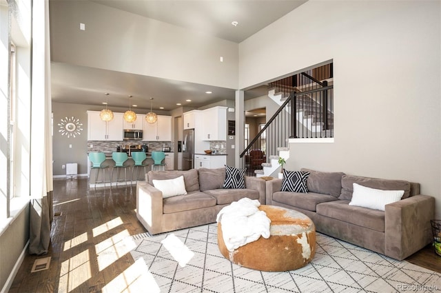 15194 W Washburn Ave, Lakewood, CO 80228 - living room with light wood-type flooring, a high ceiling, and stairs