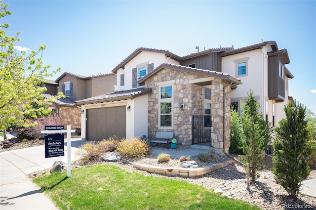 15194 W Washburn Ave, Lakewood, CO 80228 - mediterranean / spanish home with concrete driveway, a garage, stone siding, stucco siding, and a tiled roof