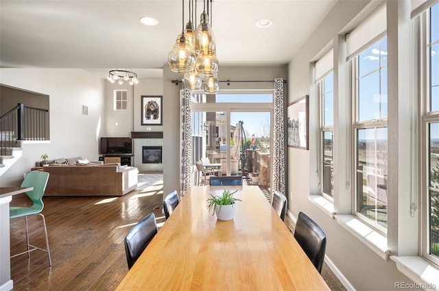 15194 W Washburn Ave, Lakewood, CO 80228 - dining space with a chandelier, hardwood / wood-style flooring, stairway, a glass covered fireplace, and recessed lighting