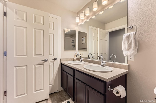 16057 E 47th Pl, Denver, CO 80239 - full bathroom with double vanity and wood finished floors