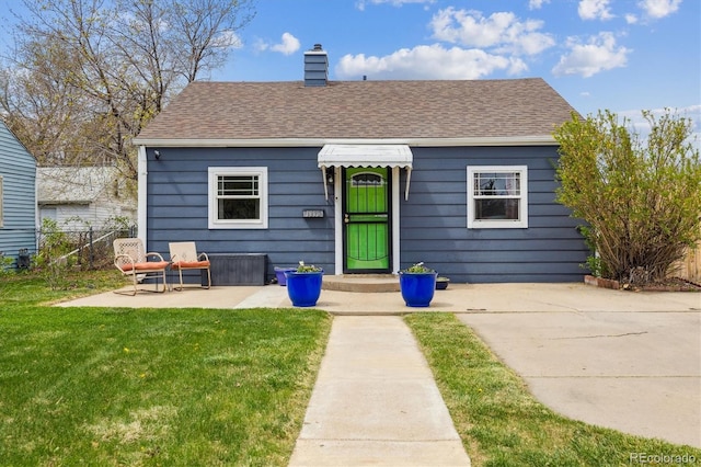 1995 Xenia St, Denver, CO 80220 - view of front of property featuring roof with shingles, fence, a front yard, and a chimney