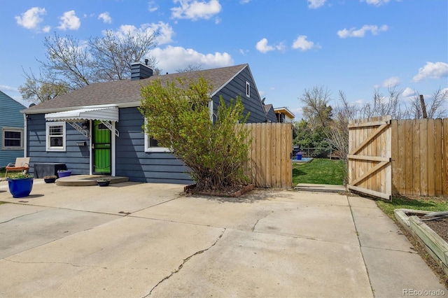 1995 Xenia St, Denver, CO 80220 - view of side of property with fence, a chimney, a patio area, and roof with shingles