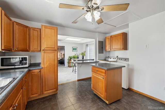 1995 Xenia St, Denver, CO 80220 - kitchen with washing machine and clothes dryer, a center island, a ceiling fan, stainless steel microwave, and electric panel
