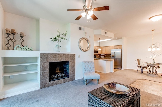 804 Summer Hawk Dr Unit 3202, Longmont, CO 80504 - living room with light colored carpet, ceiling fan, a tiled fireplace, and a chandelier