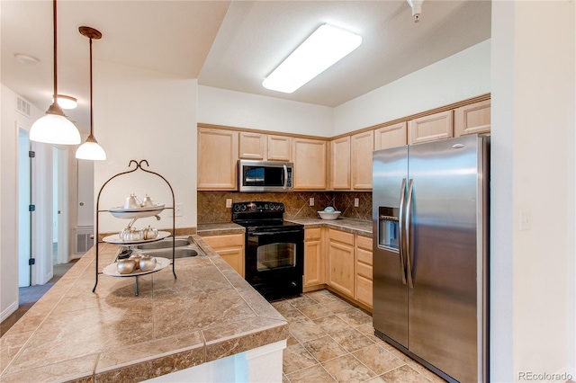 804 Summer Hawk Dr Unit 3202, Longmont, CO 80504 - kitchen with stainless steel appliances, tile countertops, light brown cabinets, a peninsula, and decorative backsplash