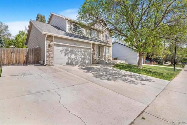 524 Rider Ridge Dr, Longmont, CO 80504 - view of front of home featuring fence, concrete driveway, a front lawn, and stone siding