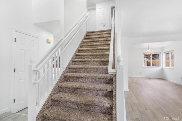 524 Rider Ridge Dr, Longmont, CO 80504 - staircase with an inviting chandelier, wood finished floors, and baseboards