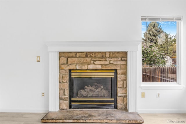524 Rider Ridge Dr, Longmont, CO 80504 - room details featuring baseboards, a glass covered fireplace, and wood finished floors