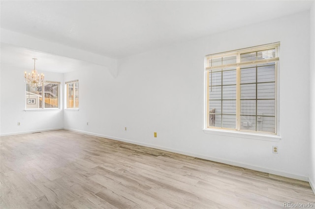 524 Rider Ridge Dr, Longmont, CO 80504 - spare room with baseboards, a notable chandelier, and wood finished floors