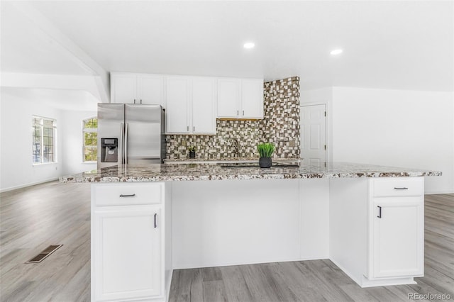 524 Rider Ridge Dr, Longmont, CO 80504 - kitchen featuring visible vents, light wood-style flooring, light stone countertops, and stainless steel refrigerator with ice dispenser