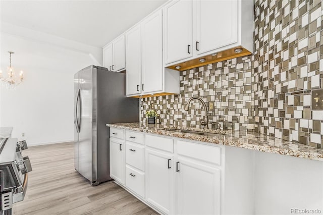 524 Rider Ridge Dr, Longmont, CO 80504 - kitchen with a sink, stainless steel appliances, a chandelier, backsplash, and white cabinets