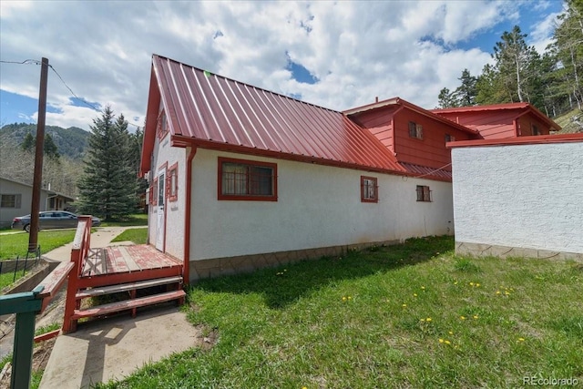 view of side of property featuring a yard and a wooden deck