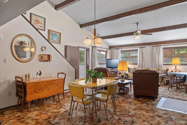 dining space featuring vaulted ceiling with beams, ceiling fan, and a textured ceiling