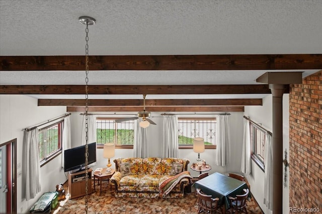 living room with brick wall, ceiling fan, beam ceiling, and a textured ceiling