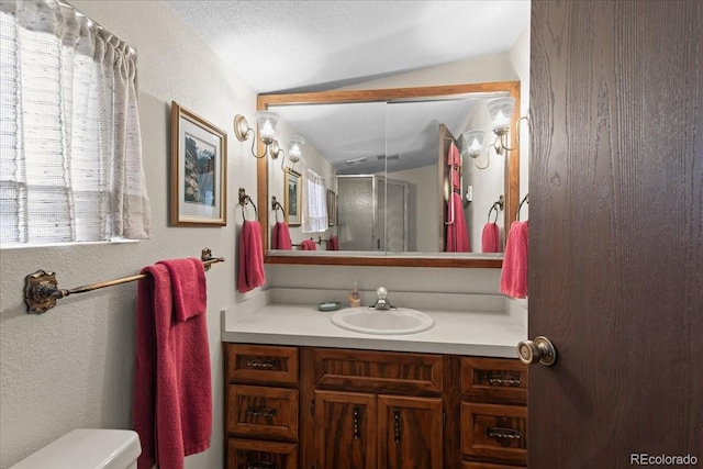 bathroom featuring vaulted ceiling, vanity, toilet, and a textured ceiling