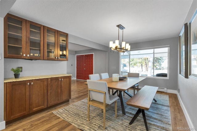 dining space featuring hardwood / wood-style flooring and a notable chandelier