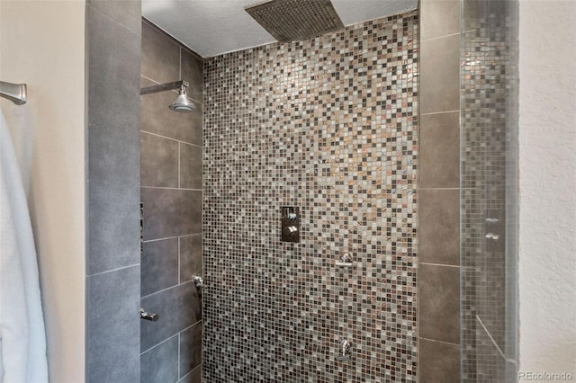 bathroom featuring tiled shower and a textured ceiling