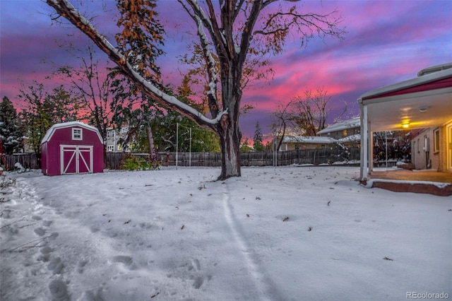 yard layered in snow with a storage shed