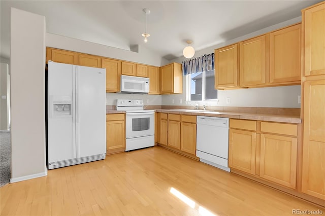 kitchen with white appliances, light brown cabinets, light wood finished floors, and a sink