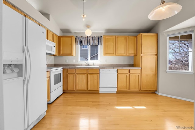 kitchen with white appliances, light wood finished floors, lofted ceiling, a sink, and tile counters