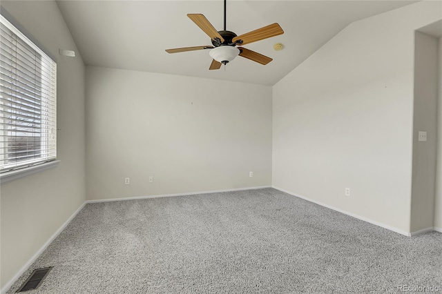 carpeted empty room with visible vents, ceiling fan, baseboards, and vaulted ceiling