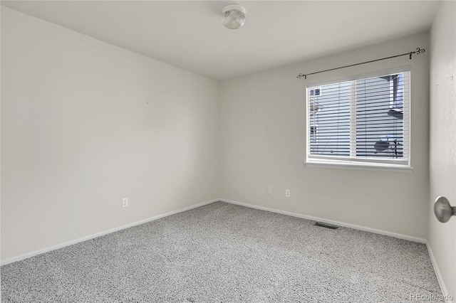 carpeted spare room with baseboards and visible vents