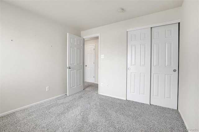 unfurnished bedroom with a closet, baseboards, and carpet