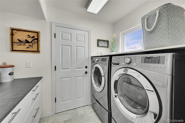 laundry room with baseboards, cabinet space, and independent washer and dryer