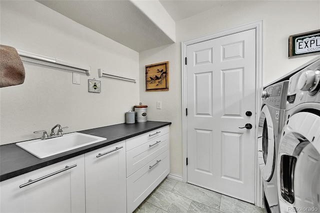 washroom featuring washing machine and clothes dryer, baseboards, a sink, and cabinet space