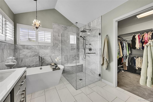bathroom with vanity, a chandelier, a freestanding tub, lofted ceiling, and a stall shower