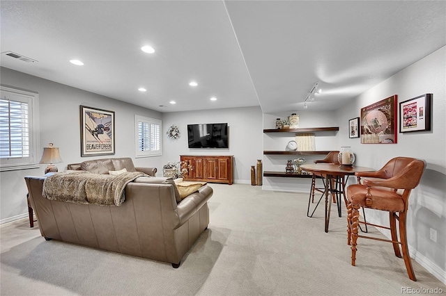 living area with recessed lighting, baseboards, visible vents, and light carpet