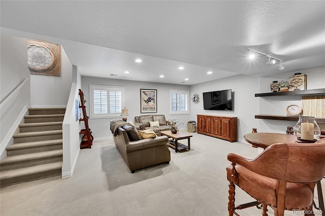 living room featuring carpet floors, stairs, baseboards, recessed lighting, and a textured ceiling