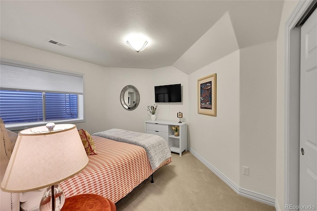 bedroom with baseboards, light colored carpet, vaulted ceiling, and visible vents