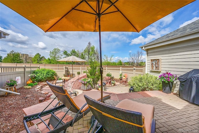 view of patio with area for grilling and a fenced backyard