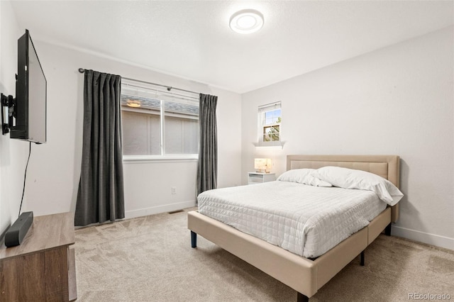 carpeted bedroom featuring baseboards and visible vents