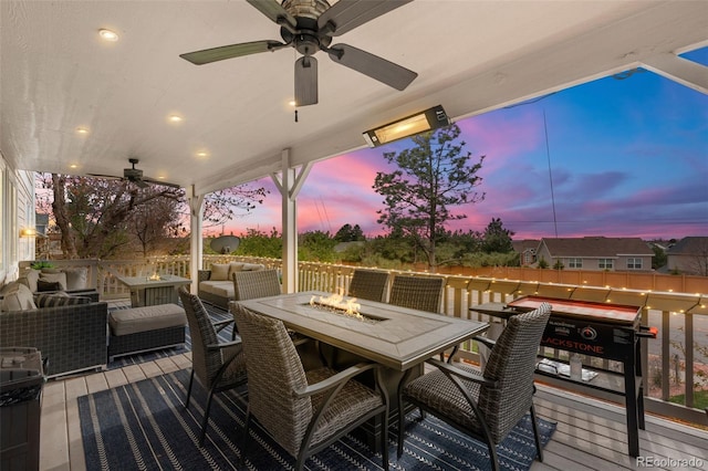 deck at dusk with outdoor dining area, an outdoor living space with a fire pit, and ceiling fan