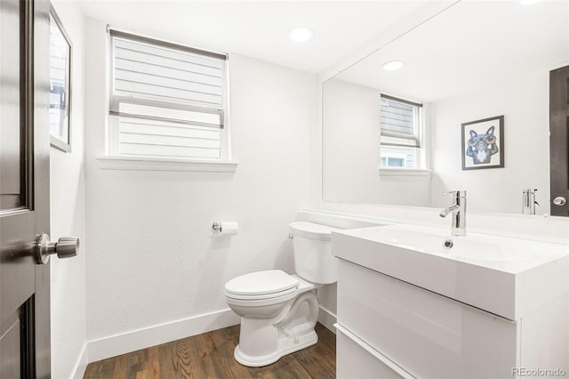 bathroom featuring vanity, toilet, recessed lighting, baseboards, and wood finished floors