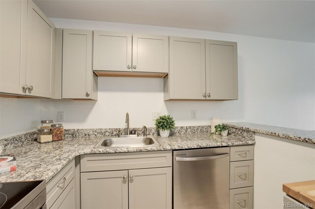 kitchen featuring a sink, stainless steel dishwasher, light stone countertops, and range