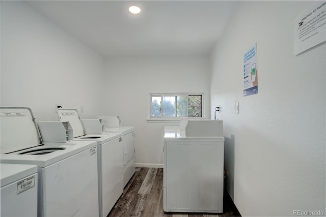shared laundry area featuring washing machine and dryer, dark wood-type flooring, and baseboards