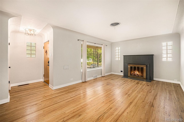 2526 W 39th Ave, Denver, CO 80211 - unfurnished living room with light wood-style floors, a fireplace, baseboards, and a chandelier